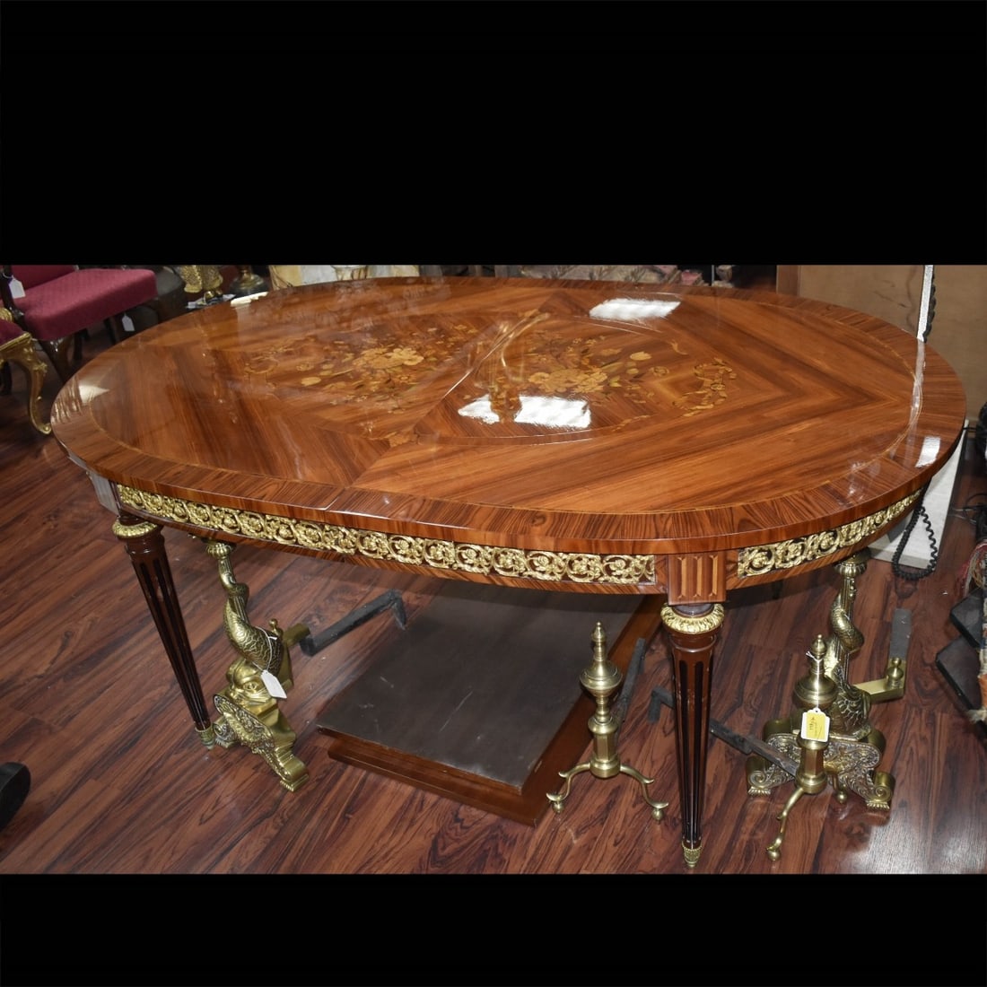 Fine French Louis XVI Style Dining Table: Fine French Mid Century Louis XVI Style Marquetry Inlaid Dining Table with Inset Ormolu Mounts. Lot includes two leaves. Oval shape top and stands on fluted tapering legs. Table (without leaves) measu