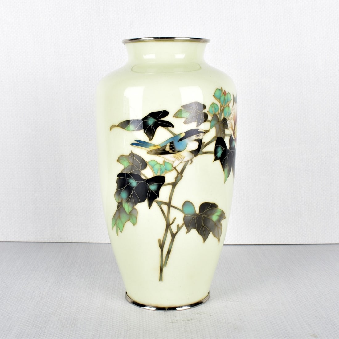 Japanese Cloisonne Vase: Japanese Cloisonne Vase Decorated with a Bird Perched on Flowering Branches on a Light Yellow Ground with Chrome Mounts. Stamped on bottom rim "Made in Japan". Late 20th century. Measures: 8-3/4" High