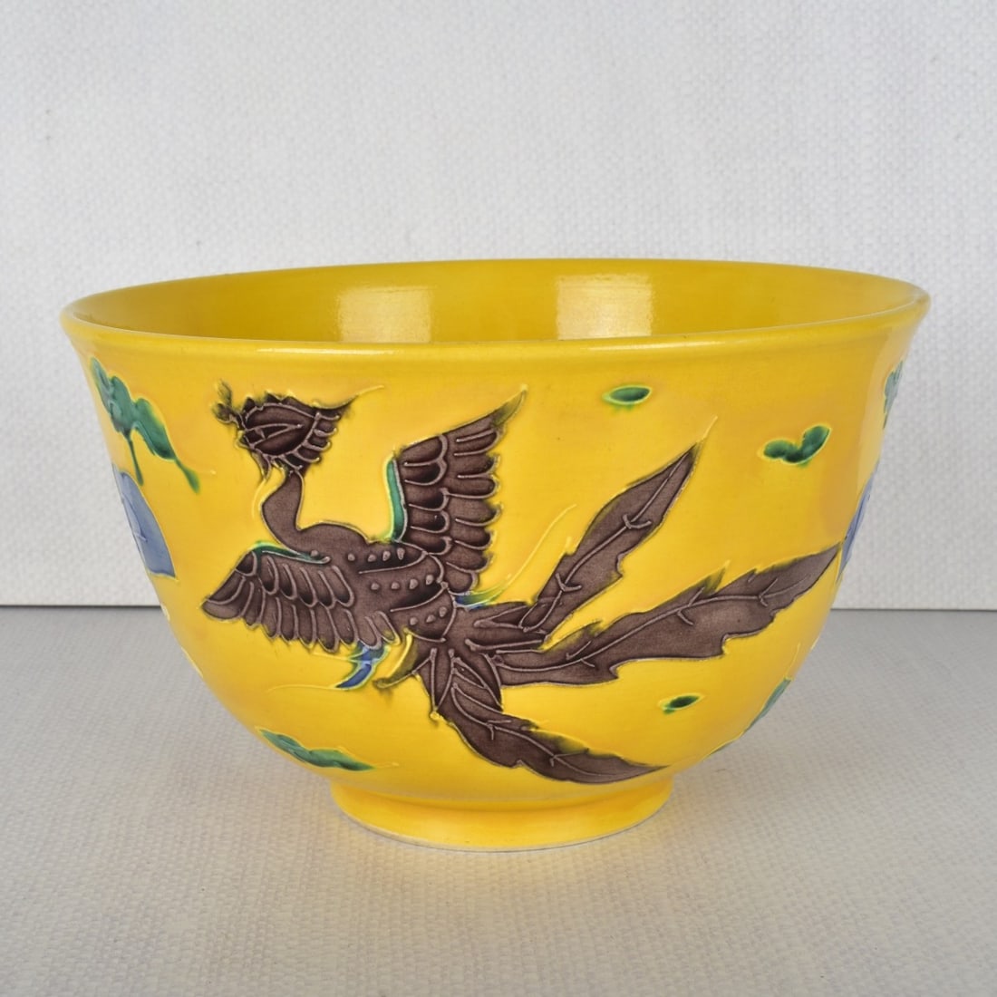 Japanese Porcelain Bowl: Japanese Porcelain Bowl Decorated with Two (2) Flying Phoenix on a Bright Yellow Ground. Marked to the bottom. Measures" 4-1/2" H, 7-1/2" Dia. Kodner Galleries offers phone and absentee bidding at a l