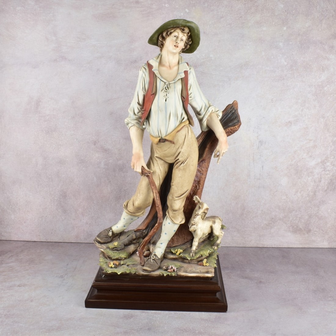 Italian Capodimonte Porcelain Figure: Italian Capodimonte Porcelain Figure of a Shepard with a Small Lamb Leaning Against a Tree Stump Mounted on a Wood Base. Signed "G. Pellati". Overall measures: 22-7/8" H, 11" W, 8-1/2" D. Kodner Galle