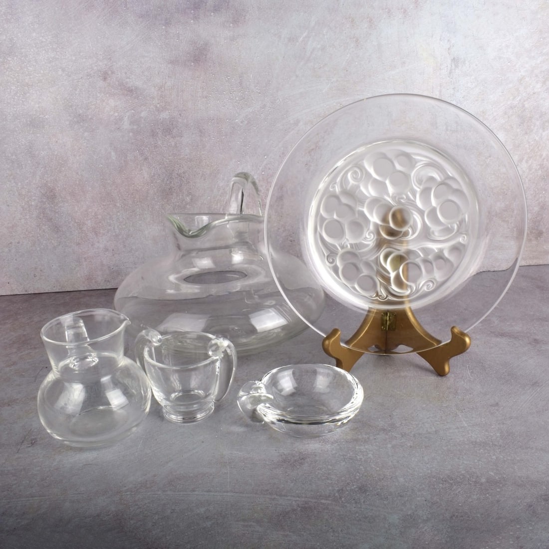 Vintage Crystal Glass Pieces: Five (5) Vintage Crystal Glass Pieces. Consisting of one (1) small Lalique plate in clear and frosted glass, signed "Lalique France", measures: 9" Dia., three (3) small Steuben vessels, all signed, ta