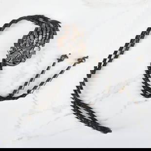Native American Bear Claw & Silver Bolo Tie: Vintage Native American Bear Claw and Silver Bolo Tie with Braided Leather. Slider measures 2-3/4" H, 1-7/8" W; tie measures 42" L. Approx. gross weight: 88.69 grams. Kodner Galleries offers phone