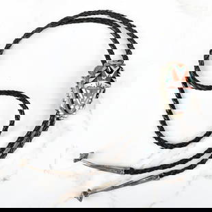 Zuni Hardstone and Silver Bolo Tie: Vintage Virginia Quam Zuni Red Coral, Turquoise, Black Onyx and Mother of Pearl Inlaid Silver Bolo Tie with Braided Leather. Signed, stamped Zuni. Slider measures 2" H, 1-14" W. L; tie measures 37"