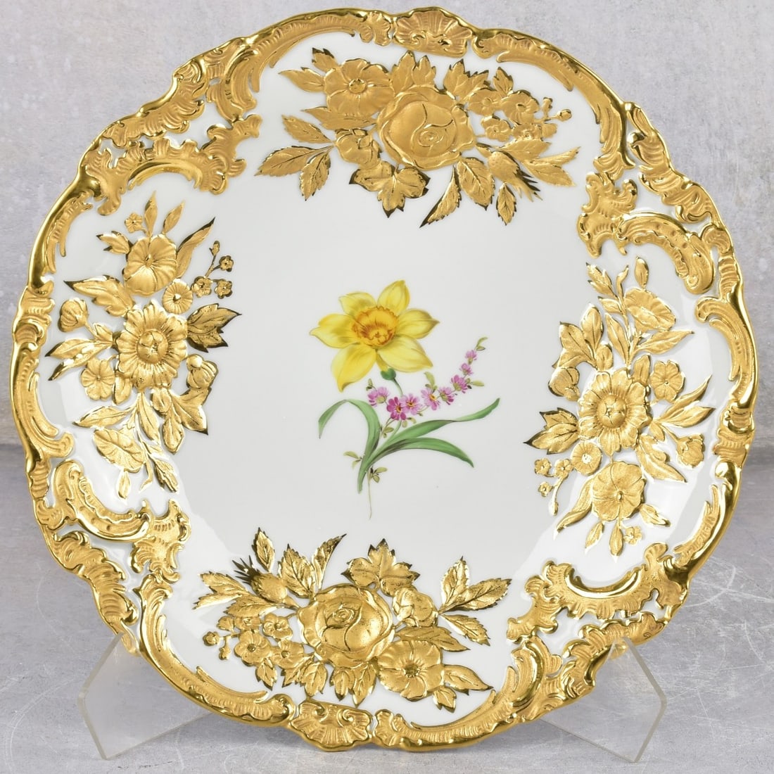 Meissen Porcelain Circular Plate: Meissen Porcelain Circular Plate With Heavy Gold Decoration with a Central Medallion of Painted Flowers and Raised Foliage Edge. Marked with the Meissen crossed swords under glaze and incised numbers.