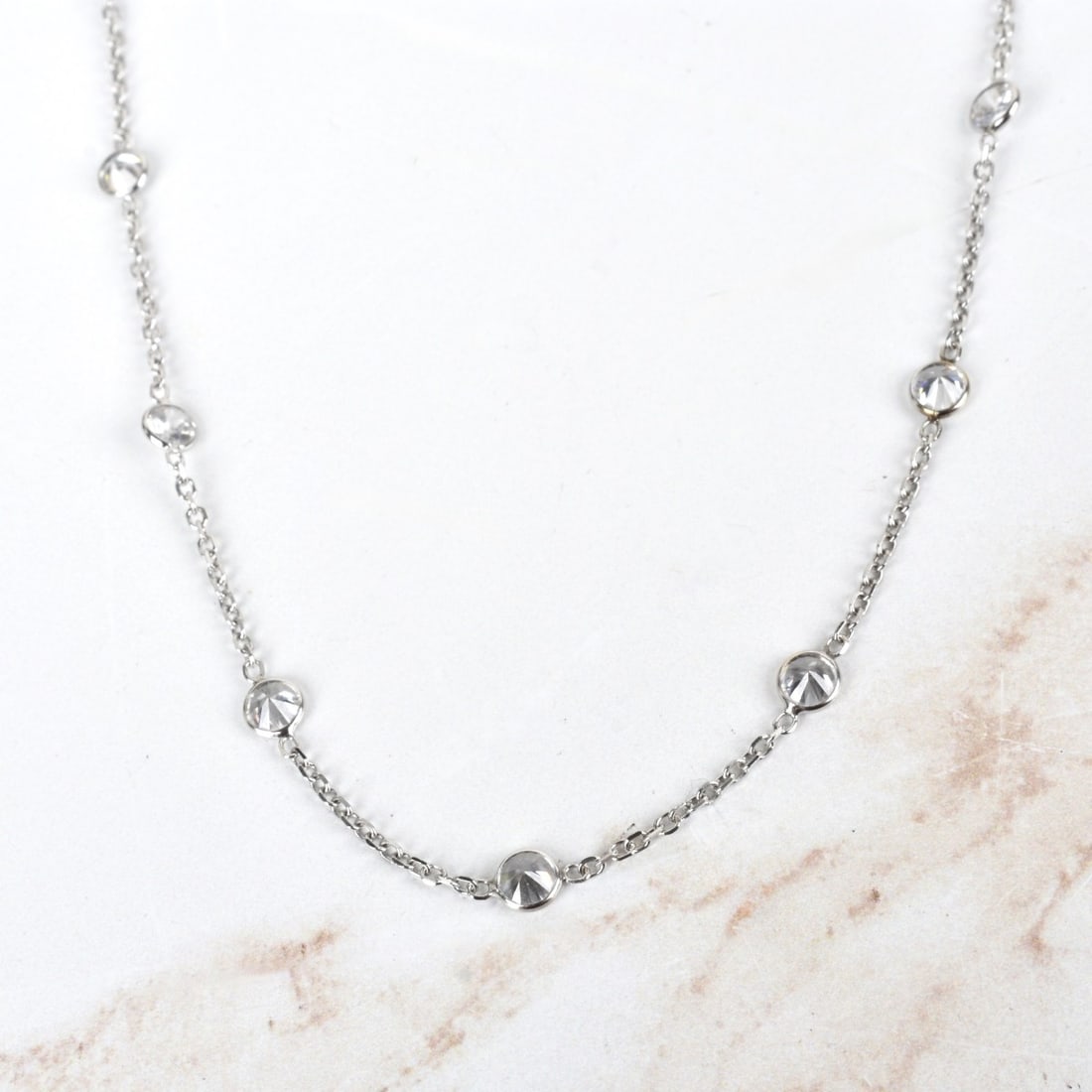 CZ and 14K Necklace: Round Cut Cubic Zirconia and 14 Karat White Gold "By the Yard" Necklace. Clasp stamped 14K. Measures 18" L. Approx. weight: 4.50 grams. Kodner Galleries offers phone and absentee bidding at a low, fla