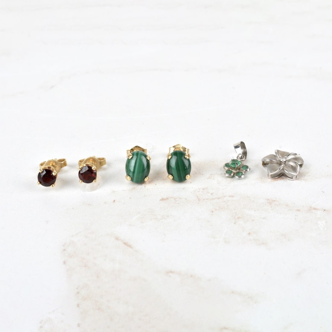 Pendants and Earrings: Lot of Four Pendants and Earrings. To include a pair of delicate round cut emerald and 18 karat white gold flower pendant, a delicate round cut diamond and 14 karat white gold flower pendant, a pair o