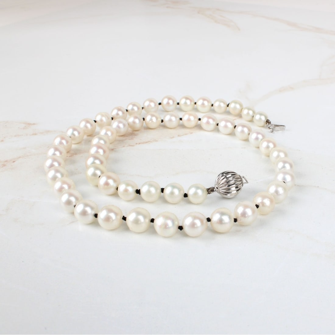 Pearl Necklace: Vintage Single Strand 7mm Pearl Necklace with 14 Karat White Gold Clasp. Pearls with good luster and polish. Clasp stamped 14K. Measures 17" L. Approx. weight: 28.04 grams. Provenance: former South Fl