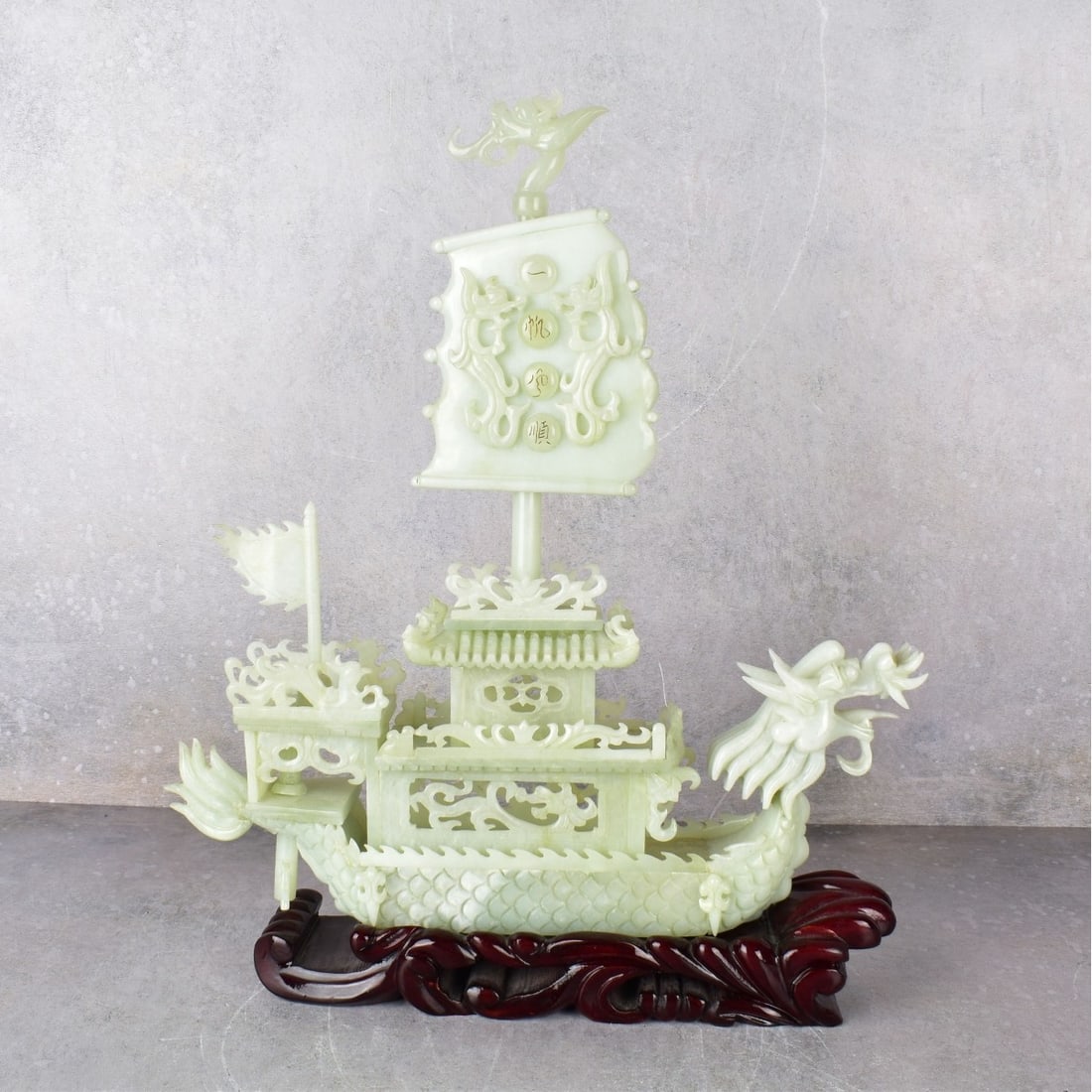 Vintage Chinese Carved Serpentine Jade Boat: Vintage Chinese Carved Serpentine Jade Boat with Carved Wood Stand. Figure exclusive of stand measures: 14" H., 12-3/4" W., 4" D. Stand measures: 2" H., 10-1/2" W., 3" D. Kodner Galleries offers phone