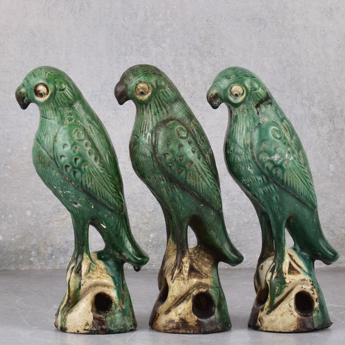 Green Pottery Parrots: Three (3) Green Pottery Parrots. Measures; 8-3/4" high, 2-3/4" wide, 4" deep. Kodner Galleries offers phone and absentee bidding at a low, flat 21% buyer’s premium without surcharge or hidden fees.