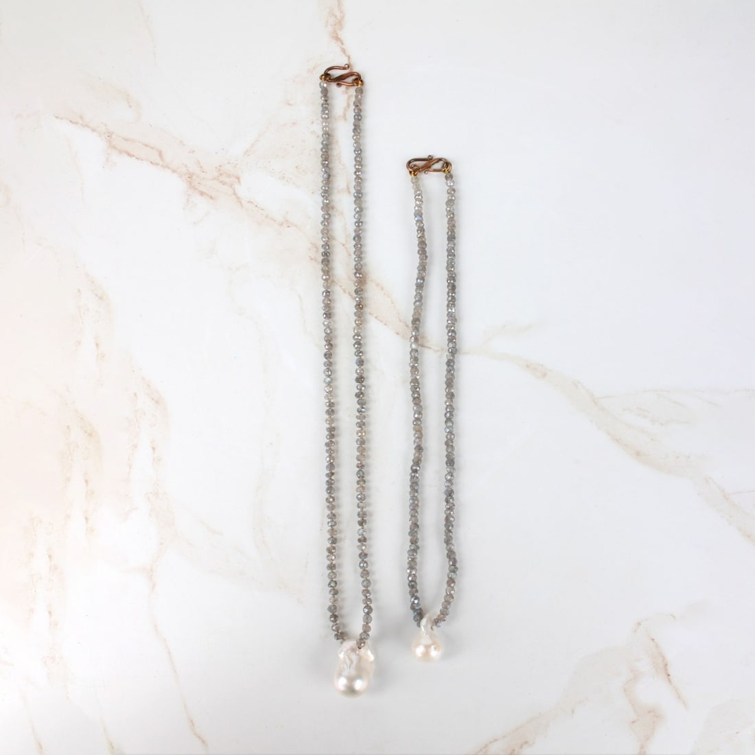 Labradorite and Pearl Necklaces: Two Vintage Labradorite Bead and Baroque Pearl Necklaces. Beads measure 4.5mm. Larger pearl measures 25 x 14.5mm. Necklaces measure 18" and 25" L. Provenance: former South Florida jewelry designer / m