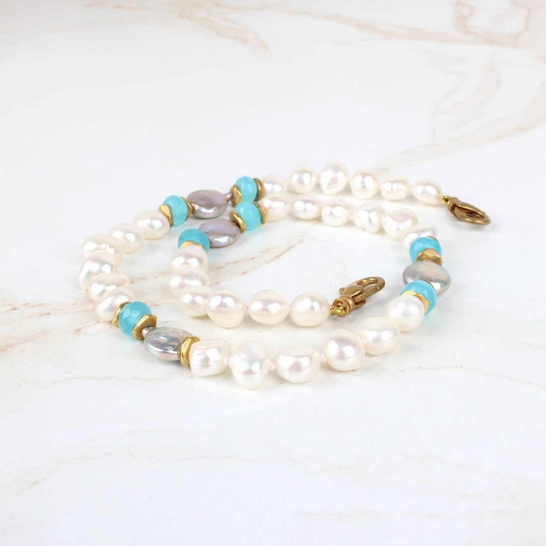 Baroque Pearl Necklace: Vintage Single Strand Baroque Pearl Necklace with Grey Pearl and Blue Stone Accents and Gold Tone Metal Clasp and Spacers. Pearls with good luster and polish. Measures 16" L. Provenance: former South 