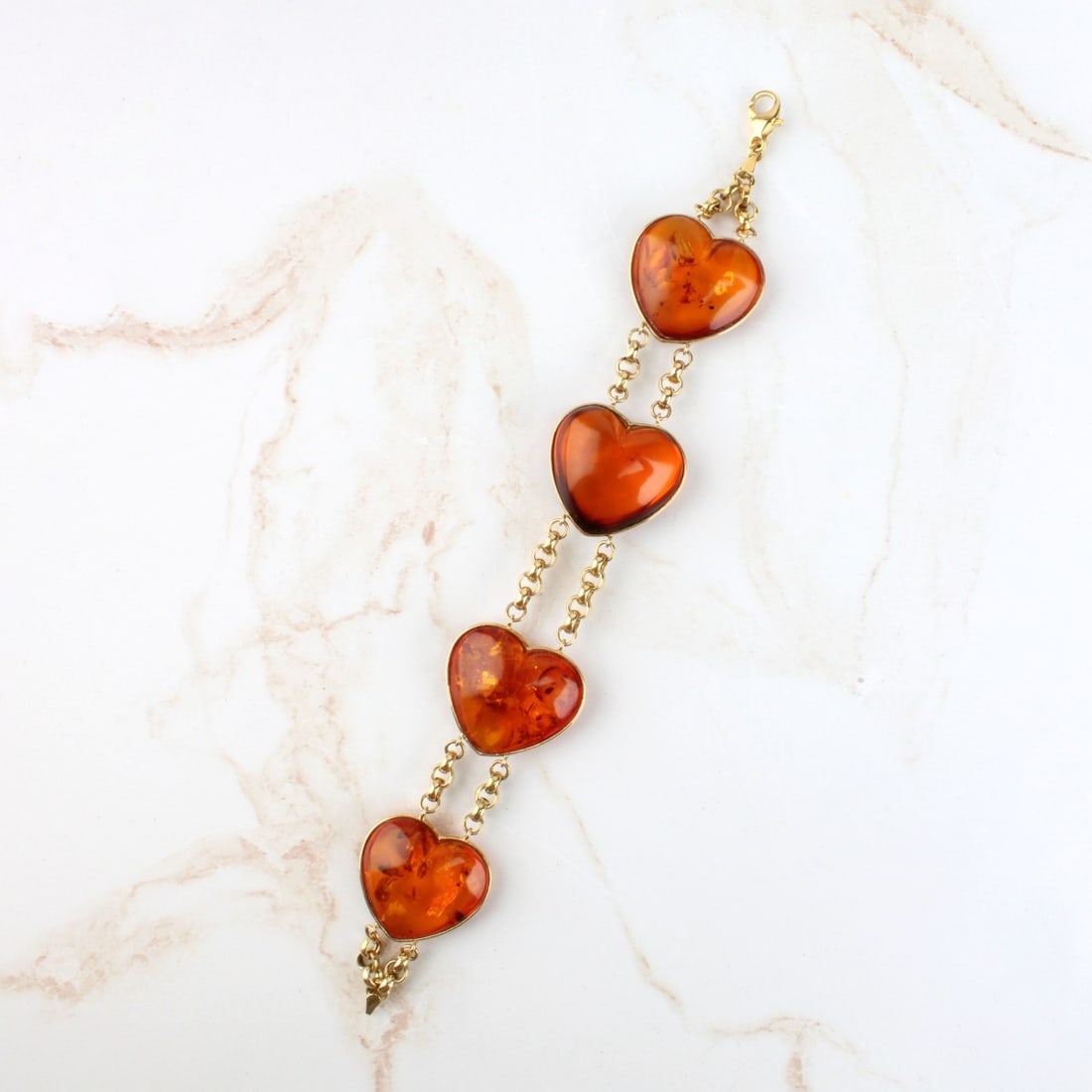 Amber and 18K Bracelet: Vintage Heart Shape Amber and 18 Karat Yellow Gold Link Bracelet. Stamped 750. Measures 8-3/8" L, 1-1/8" W. Approx. weight: 31.53 grams. Kodner Galleries offers phone and absentee bidding at a low, fl