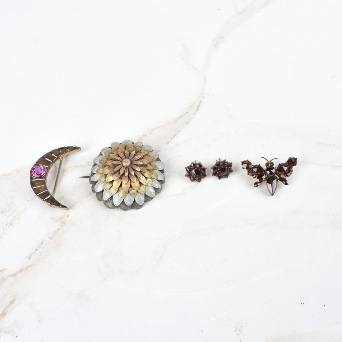 Antique Silver Jewelry: Collection of Antique Victorian Silver Jewelry. To include a flower pin, a crescent pin with man made ruby, and garnet and silver ear studs and butterfly pin. Flower pin measures 1-1/2" diameter; ear