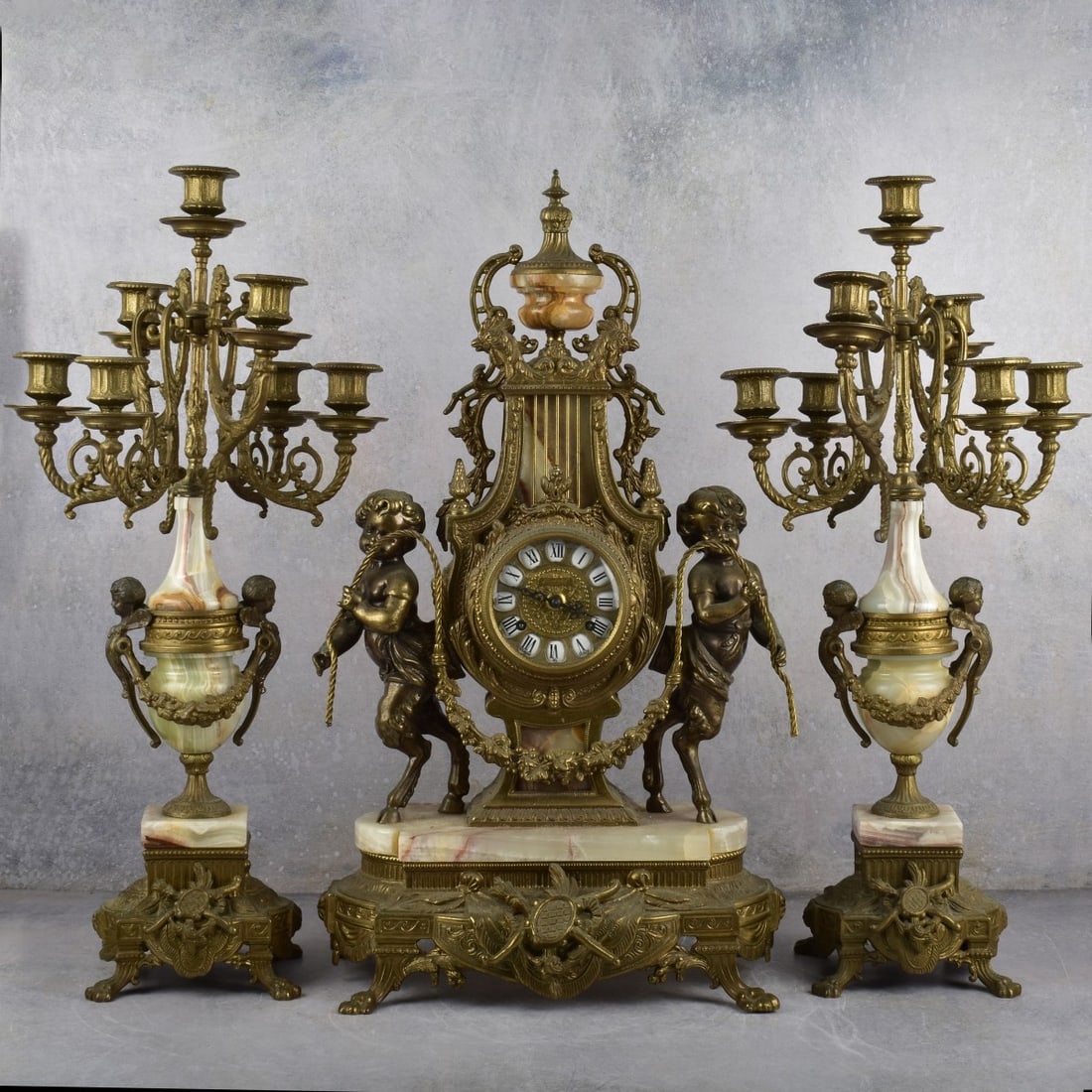 Brass and Pink Onyx Garniture Set: Mid 20th Century Italian Brass and Pink Onyx Garniture Set. Measures: 24-1/2" high, 14" wide, 7-1/2" deep. Kodner Galleries offers phone and absentee bidding at a low, flat 21% buyer’s premium witho