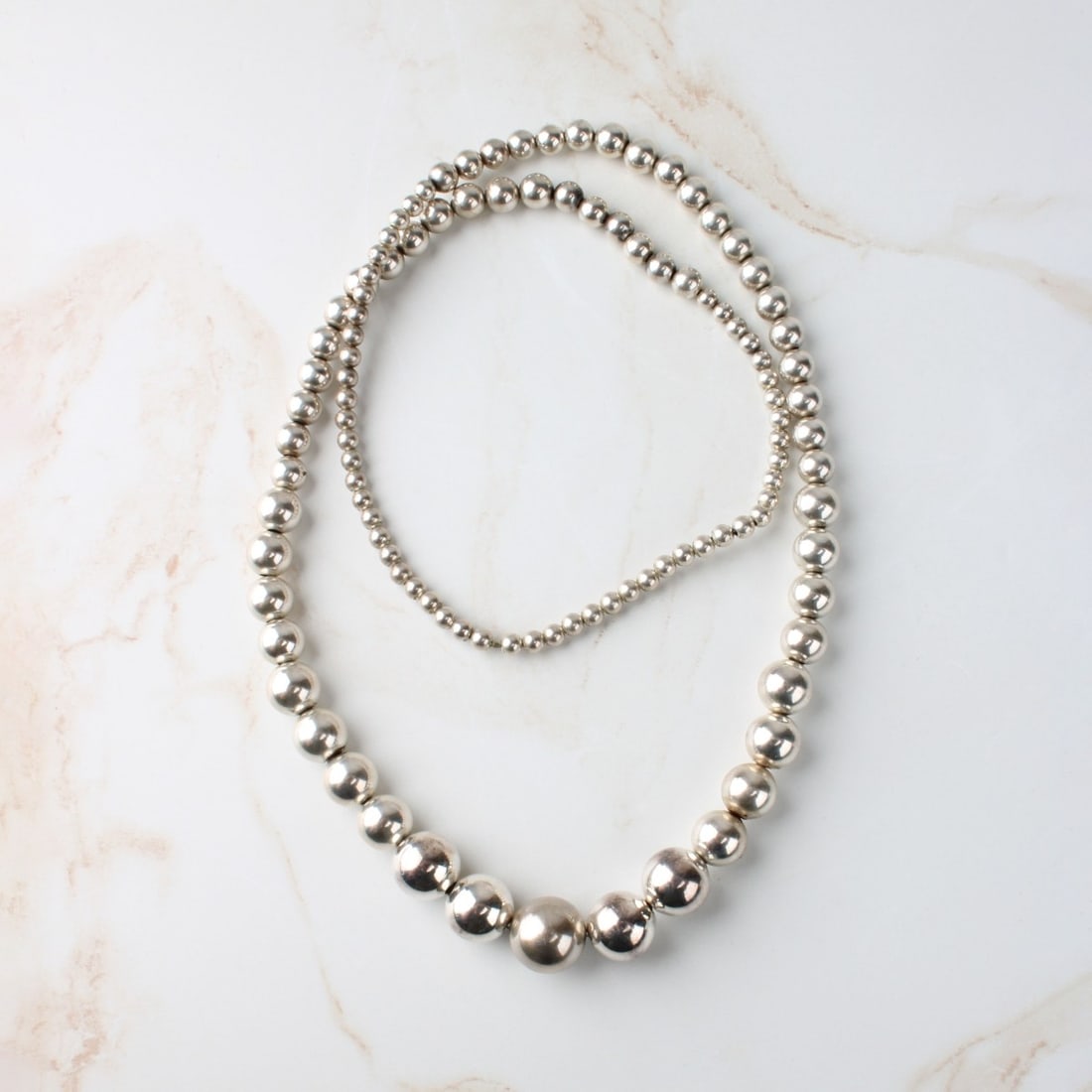 Silver Bead Necklace: Vintage 5.0-16.0mm Graduated Silver Bead Necklace. Necklace measures 30" L. Approx. weight: 55.53 grams. Condition: Good vintage condition. Estimate: $100.00 - $300.00 In-House Shipping: $40.00