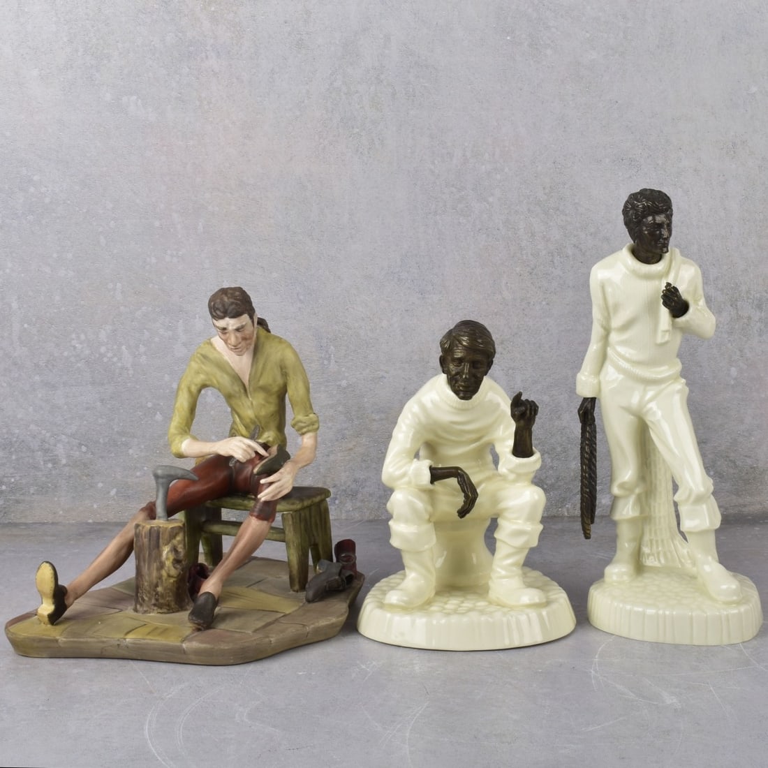 English Bone China Figurines: English Bone China Figurines. Consisting of two (2) Minton bronze and porcelain figures, one (1) "The Fisherman" and one (1) "The Travelers Tale" also one Coalport porcelain "Shoe Cobbler" figure. Lat