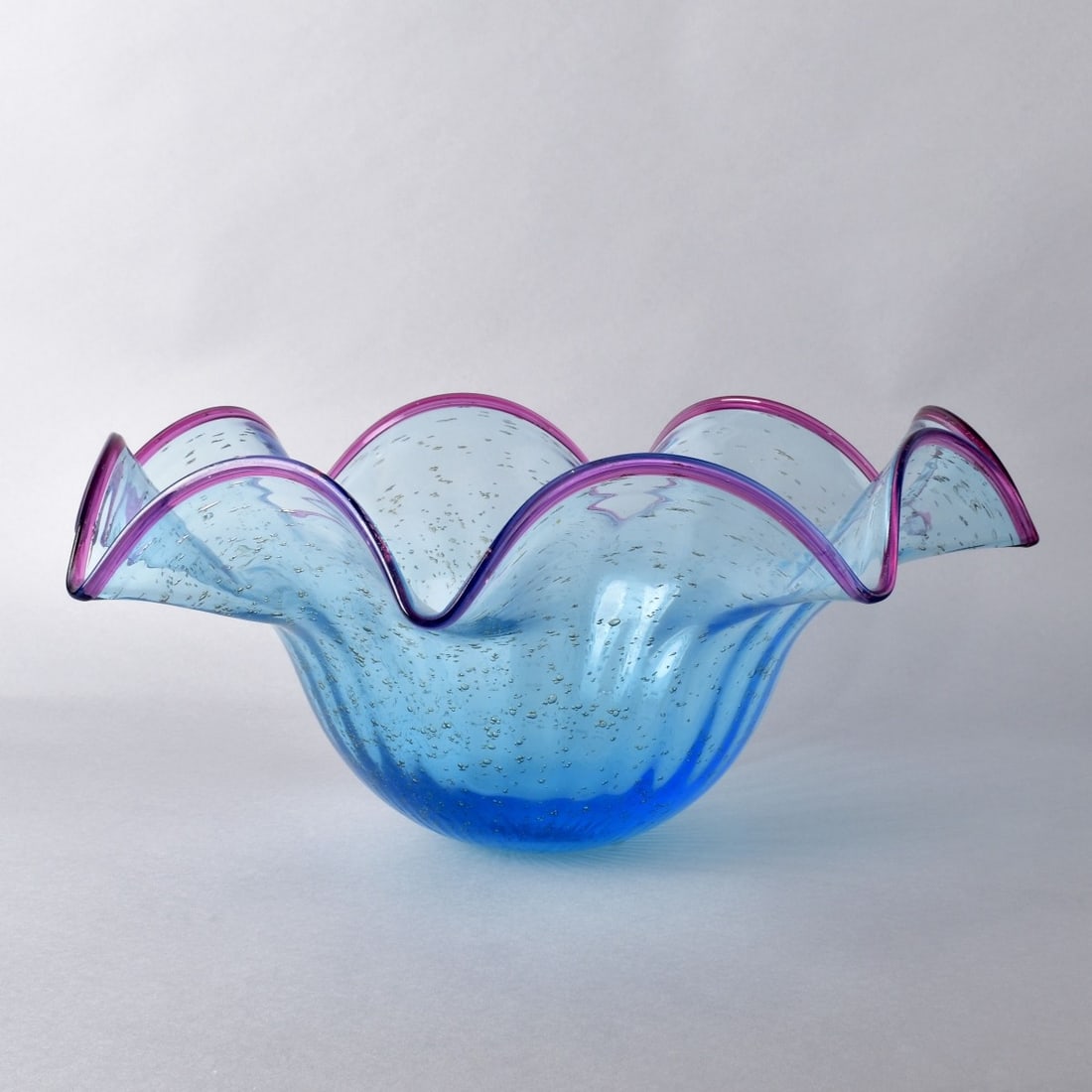 Large Art Glass Handkerchief Bowl: Large Art Glass Handkerchief Bowl. Small controlled Bubble with Blue Tint and Purple edge. Unsigned. Measures 8-1/2"H x 19" Diameter. Kodner Galleries offers phone and absentee bidding at a low, flat