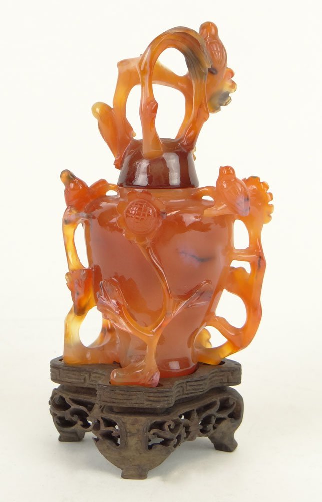 Chinese Carved Carnelian Covered Vase with Protruding B: Chinese Carved Carnelian Covered Vase with Protruding Branch and Bird Decoration and with Carved Wood Stand. Unsigned. Good Condition or Better. Measures 2-1/2 Inches Wide. Shipping $34.00