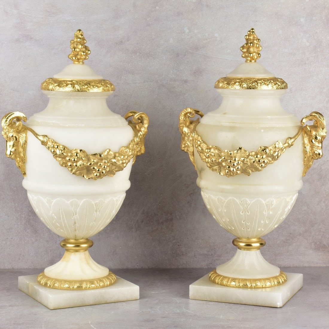 Contemporary Alabaster Urns: Pair of David Michael Contemporary Alabaster Urns Hand Carved Alabaster Urns with 24k Gold Plating Over Bronze Castings Featuring Two Beautiful Ram Heads and Detailed Ornamental Scrolls. Hand crafted