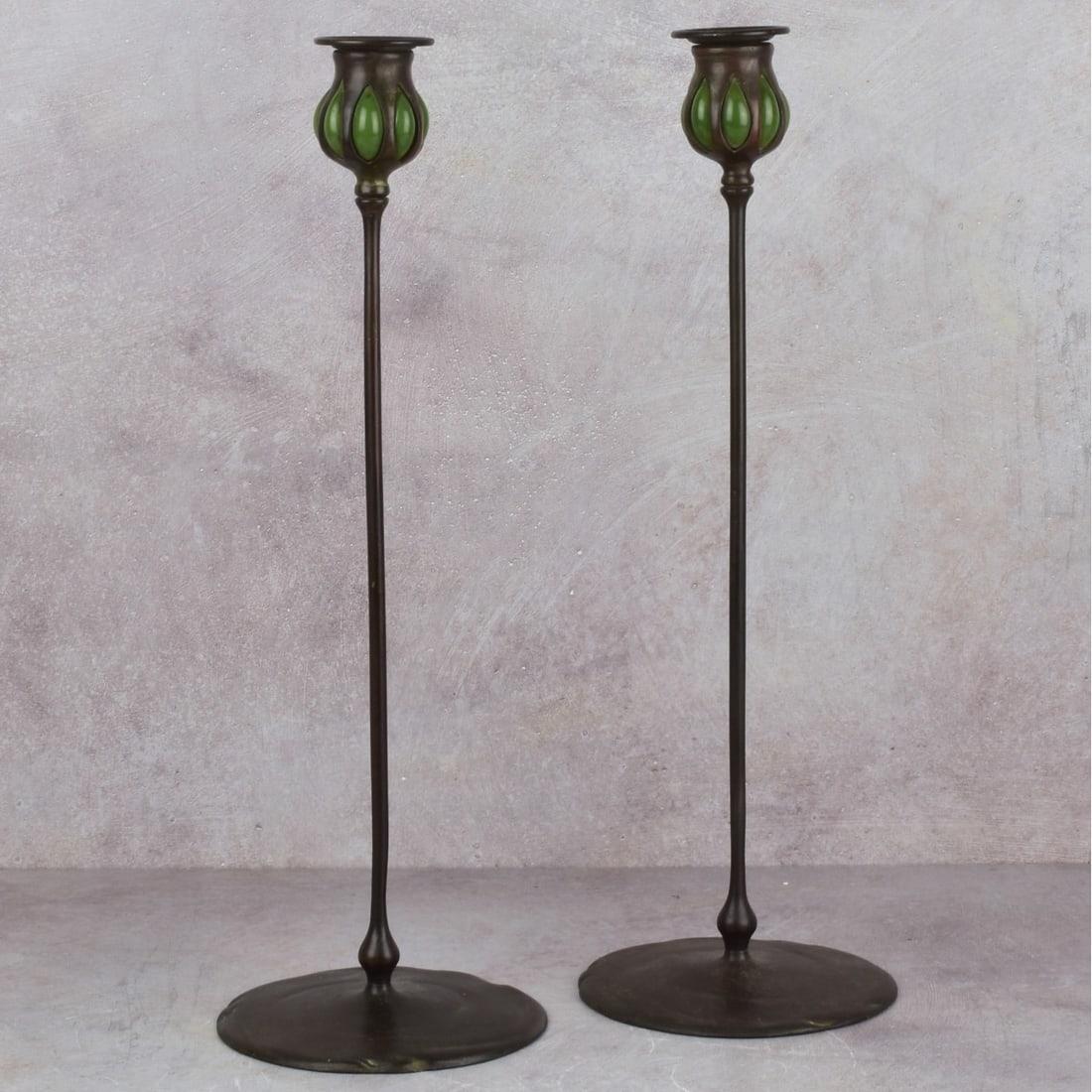 Pair of Tiffany Studios Candlesticks.: Tiffany Studios Art Nouveau Bronze Candlesticks with Green Favrile Glass and Puddle Bases. Impressed "TIFFANY STUDIOS NEW YORK 22321" to bottoms. Measures: 17-1/2" high, bases measure: 5-3/4" diameter