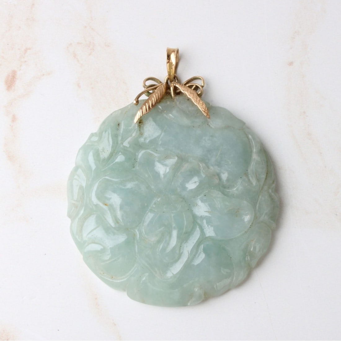 Jade and 14K Pendant: Vintage Chinese Floral Carved Celadon Jade and 14 Karat Yellow Gold Pendant. Stamped 14K. Measures 2-1/4" L, 2" diam. Approx. weight: 33.15 grams. Kodner Galleries offers phone and absentee bidding at