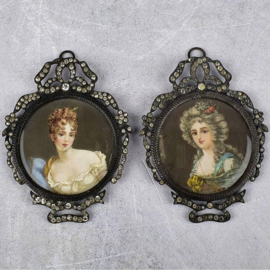 Fine Hand Painted French Miniatures: Two (2) 19th Century Finely Hand Painted French Miniature Portraits of Beauties. Framed in elaborate ribbon frames with inset rhinestones. Both artist signed right hand side. Overall with frames measu