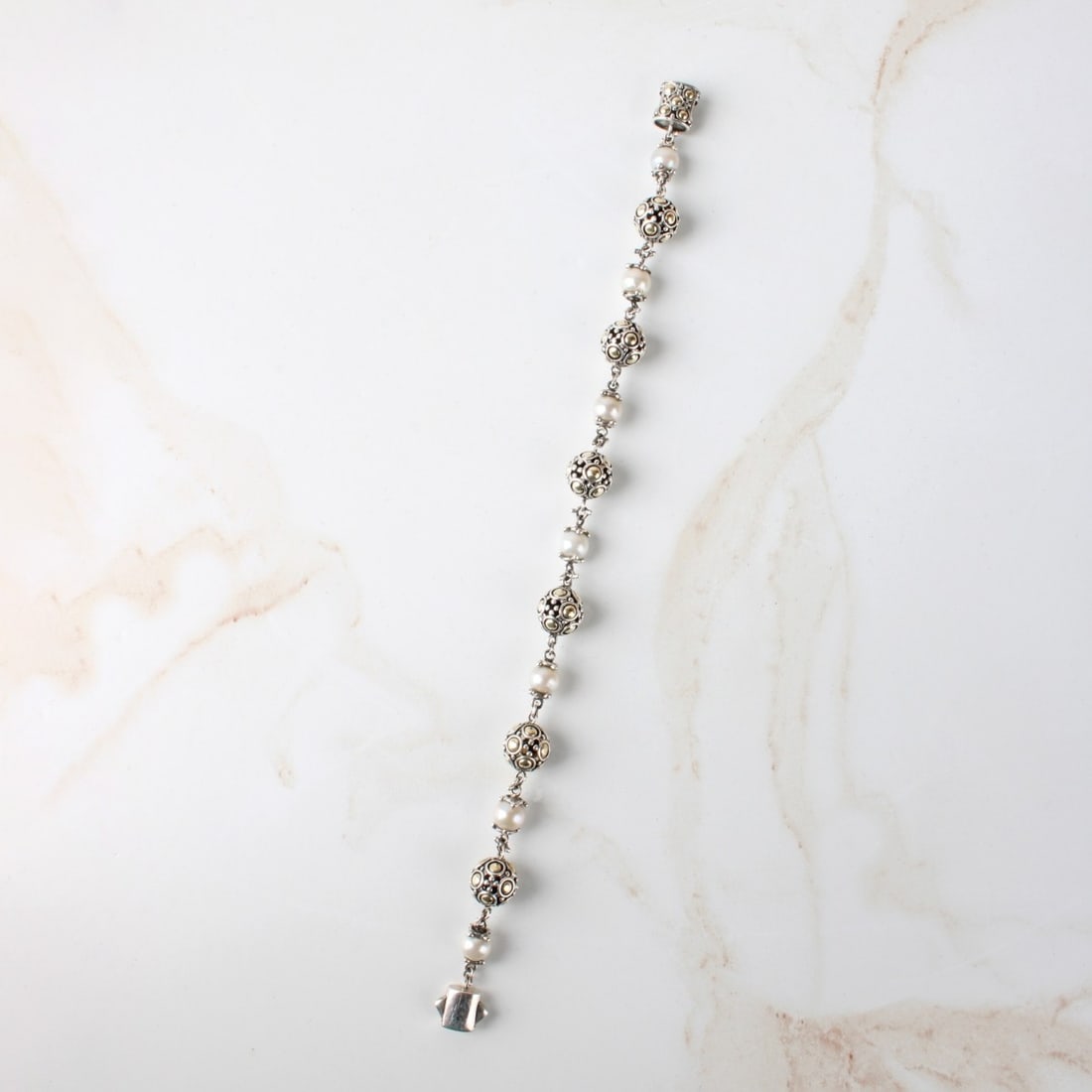 John Hardy Silver Bracelet: Vintage John Hardy 6mm Pearl and Sterling Silver Bracelet. Signed (log0). Measures 7-1/2" L. Approx. weight: 19.32 grams. With John Hardy storage pouch. Kodner Galleries offers phone and absentee bidd