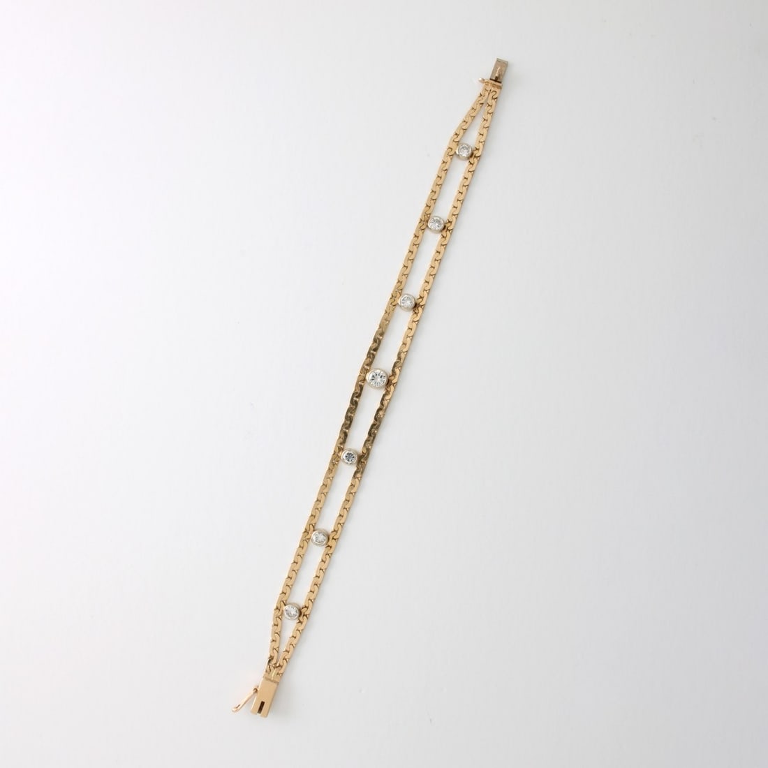 Diamond and 14K Bracelet: Retro Diamond and 14 Karat Yellow Gold Bracelet. Set in the center with an approx. .30 carat round brilliant cut diamond and flanked by approx. 1.50 carat TW six round brilliant cut diamonds.