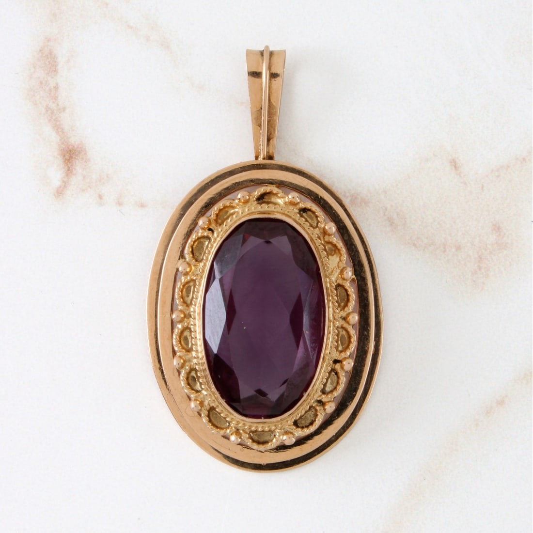 Amethyst and 14K Pendant: Vintage Oval Cut Amethyst and 14 Karat Yellow Gold Pendant. Amethyst with vivid color. Pendant measures 1-3/4" L, 1" W. Approx weight: 10.70 grams. Kodner Galleries offers phone and absentee bidding