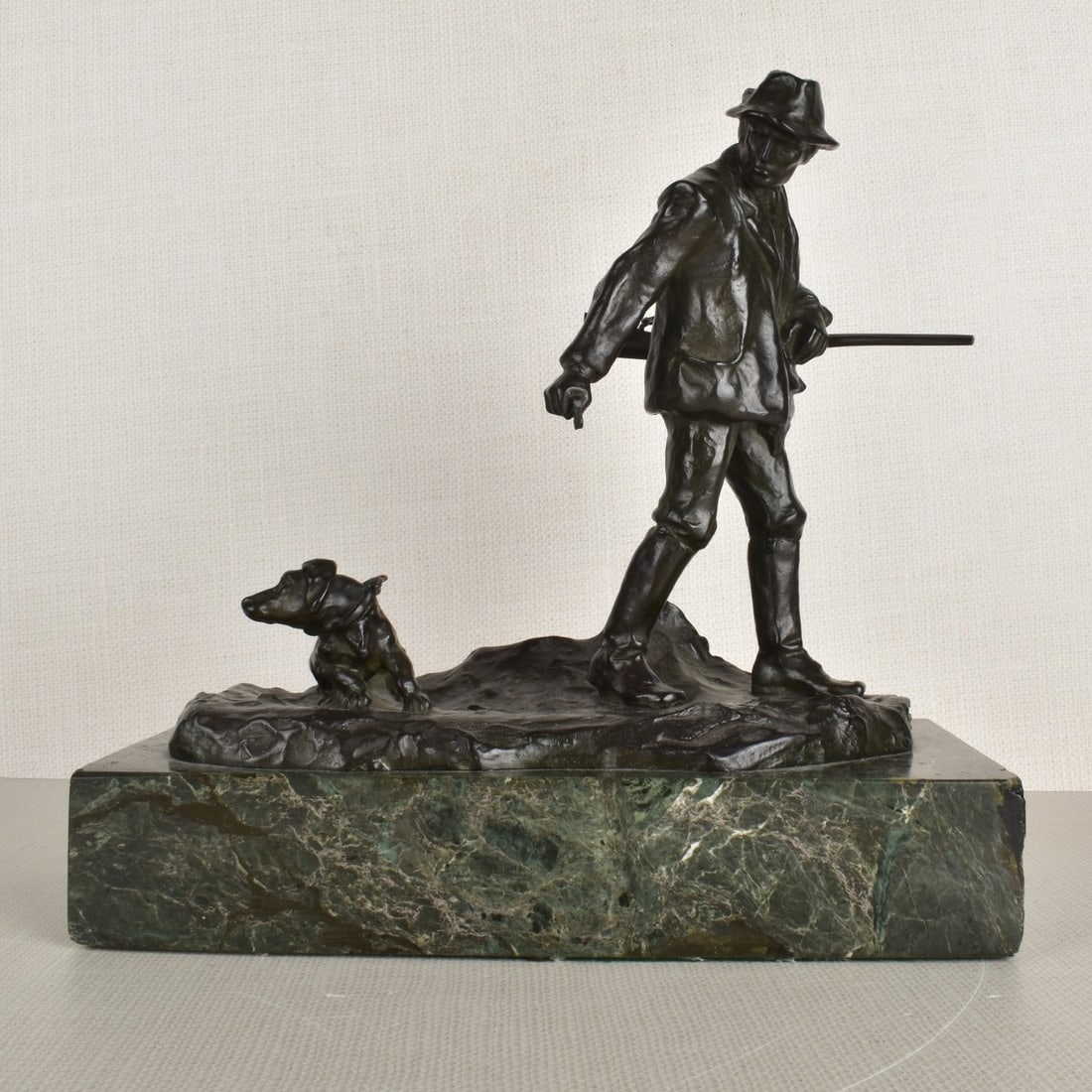 Hans Muller, (Austrian, 1873-1937): Hans Muller, (Austrian, 1873-1937), Bronze Figurine of a Hunter with his Rifle and his Dog to his Side. Signed "H. Muller" in the bronze. Figure measures: 8-1/2" H, base measures: 2" H, 10-3/4" L,