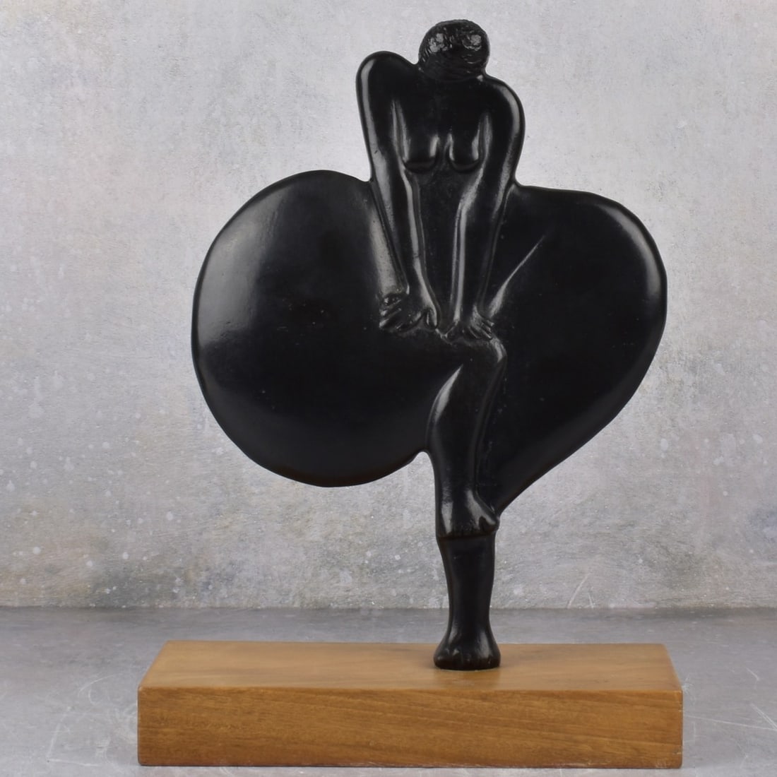 Bronze Sculpture of a Woman: Bronze Sculpture of a Woman Trying to Push Her Air Filled Dress Down, Mounted on a Rectangular Wood Base. Signed in the bronze. Measures: 12-1/8" high, 9" wide, 1" deep. wood base measures: 1-1/2"