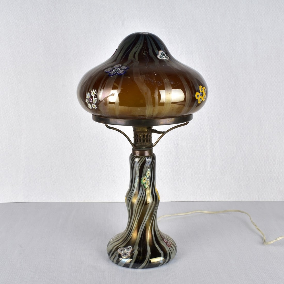 Art Nouveau Style Art Glass Lamp: Art Nouveau Style Two (2) Piece Mushroom Shape Art Glass Table Lamp. Decorated with heavy enameled flowers and raised flowers as if Millefiori. Unsigned. 20th century. Measures: 18-1/2" H, 9-1/2" W.