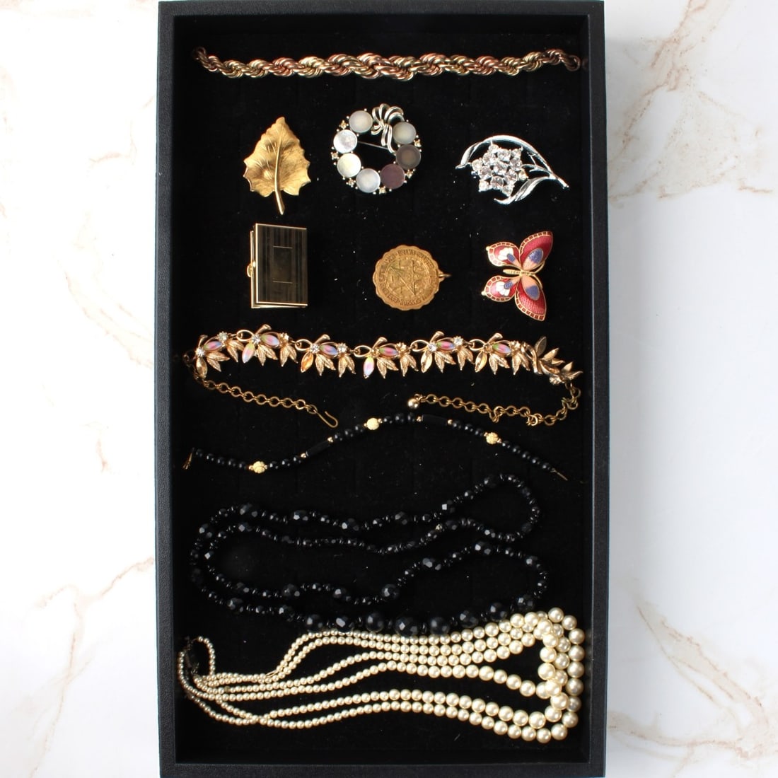 Tray Lot of Vintage Fashion Jewelry: Tray Lot of Vintage Fashion Jewelry. To include necklaces, bracelets, and pins. Some pieces accented with faux diamonds and enamels. Pearl necklace with sterling silver clasp. Kodner Galleries offers