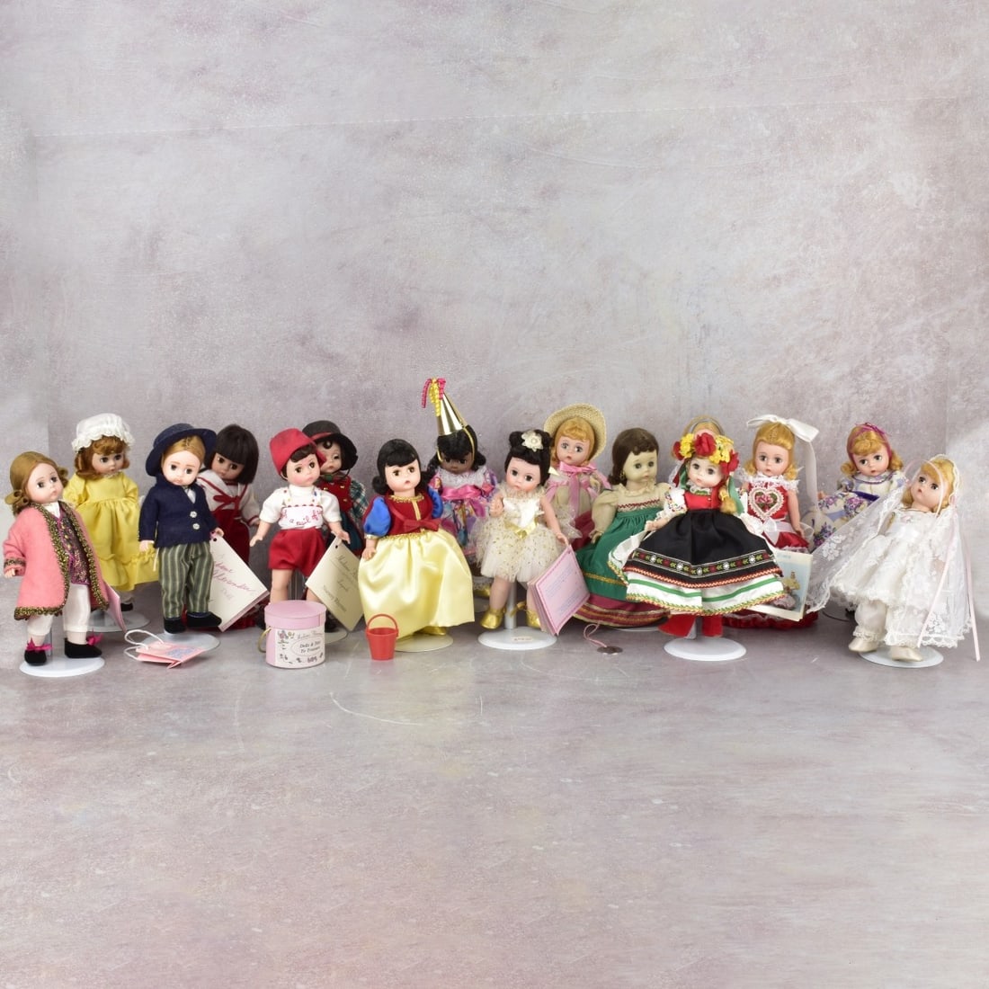 Vintage Madame Alexander Dolls: Sixteen (16) Vintage Madame Alexander Dolls Many with Original Lable. Girl with party hat measures: 8" tall. Kodner Galleries offers phone and absentee bidding at a low, flat 21% buyer’s premium wit