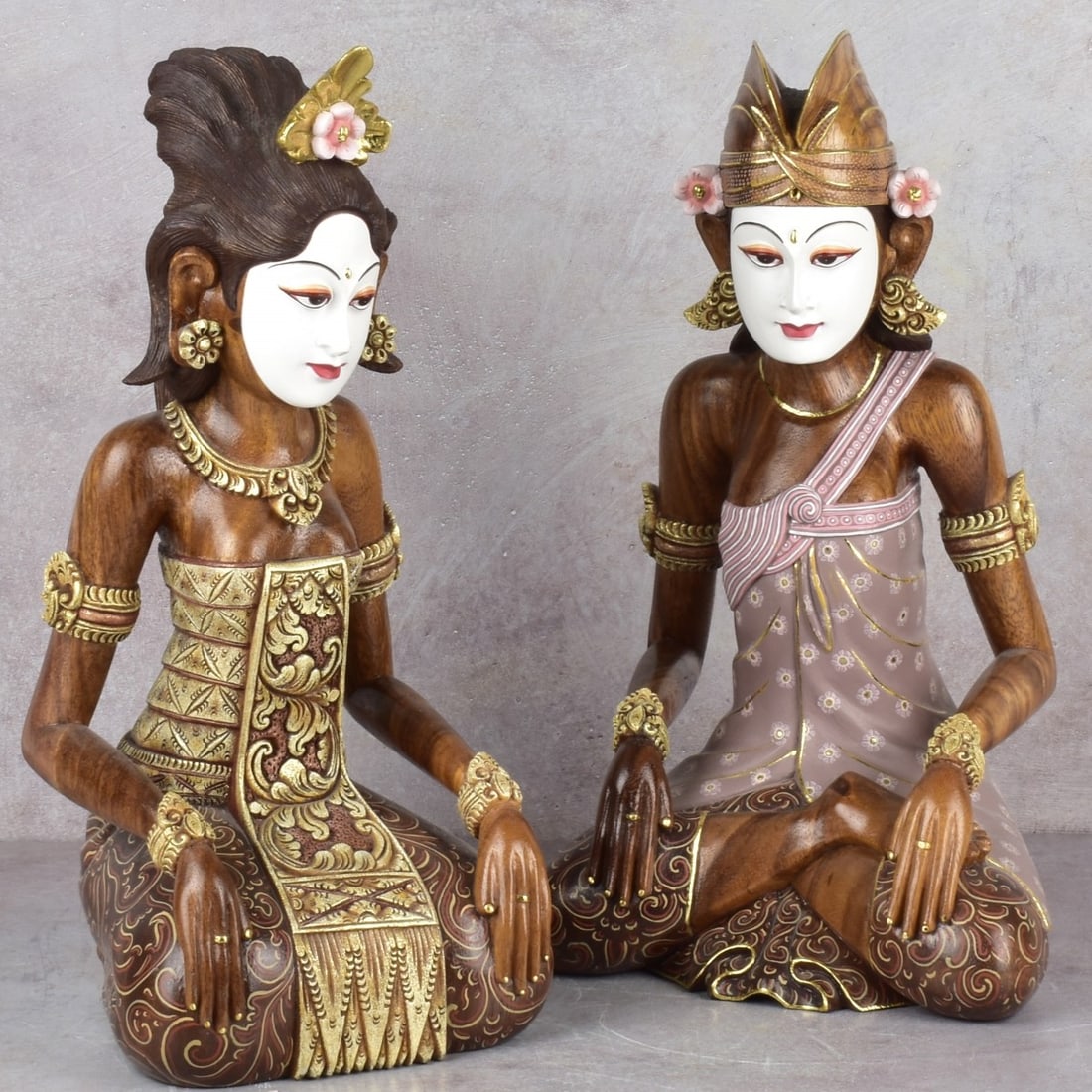 Balinese Seated Figures: Two (2) Carved Hardwood and Painted Balinese Figures in Seated Poses, Wearing Traditional Clothing and Headpieces. Measures: 16" high, 6-3/4" wide, 7-1/4" deep. Kodner Galleries offers phone and