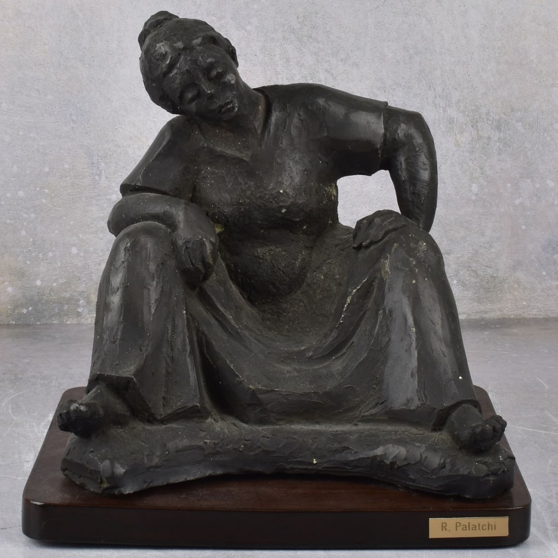 Painted Pottery Sculpture of a Lady: Painted Pottery Sculpture of a Seated Lady. Incised "R. Palatchi 87" to the base as well as an engraved name plate. Mounted to a wood base. Figure measures: 9" high, 9-1/4" wide, 7-3/4" deep, base