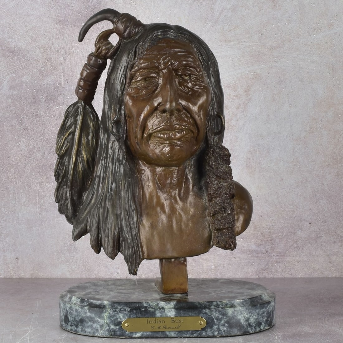 Charles Marion Russell, American (1864-1926): Charles Marion Russell, American (1864-1926) "Indian Bust" Mounted to a Green-White Marble Base. Signed "CM Russell" in the bronze and attached name plate reading " Indian Bust C.M. Russell". Bust