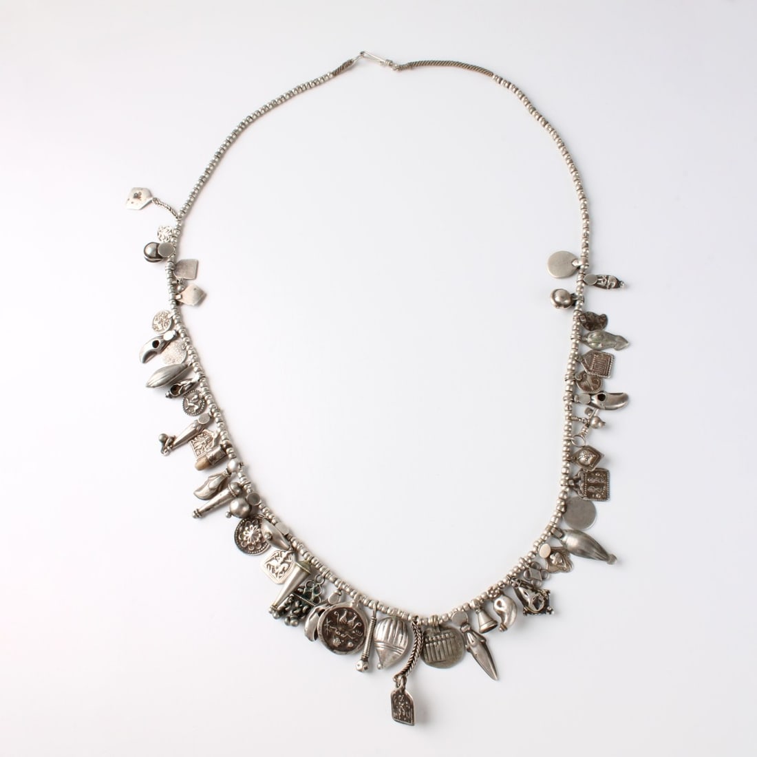 Silver Charm Necklace: Vintage Long Silver Charm Necklace. Set with numerous antique style charms. Tests 800-925 silver. Measures 35" L. Approx. weight: 118.72 grams. Condition: Good condition. Estimate: $200.00 - $400.00