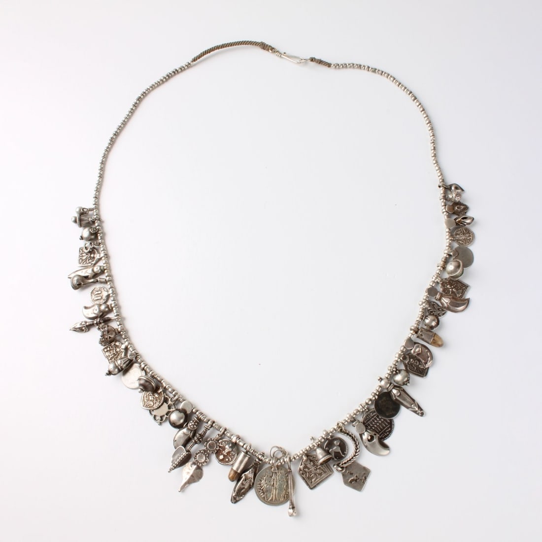 Silver Charm Necklace: Vintage Long Silver Charm Necklace. Set with numerous antique style charms. Tests 800-925 silver. Measures 30" L. Approx. weight: 91.80 grams. Condition: Good vintage condition. Estimate: $200.00 -