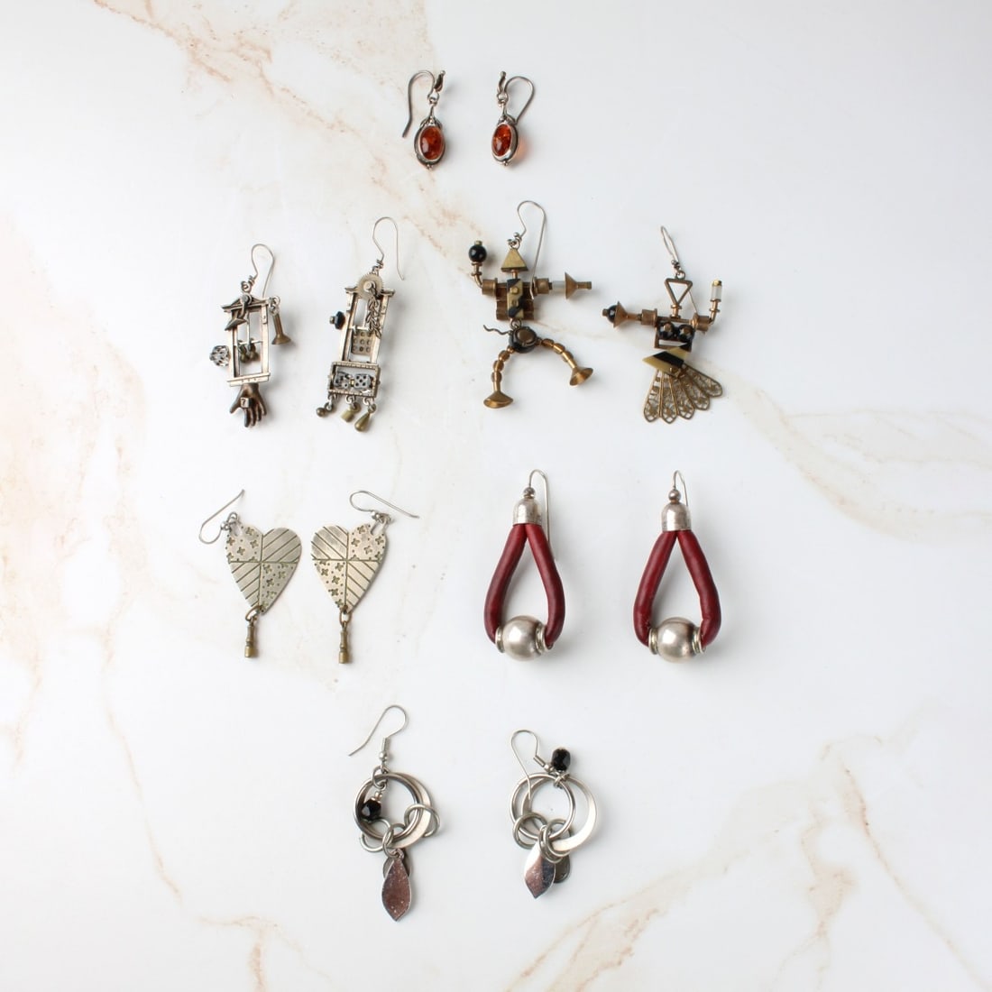 Vintage Modern Earrings: Six Pair of Vintage Modern Designer Earrings. To include silver and mixed metals with silver hoops. One pair accented with leather another with amber. Pair with leather measure 2-1/4" L, 1" W.