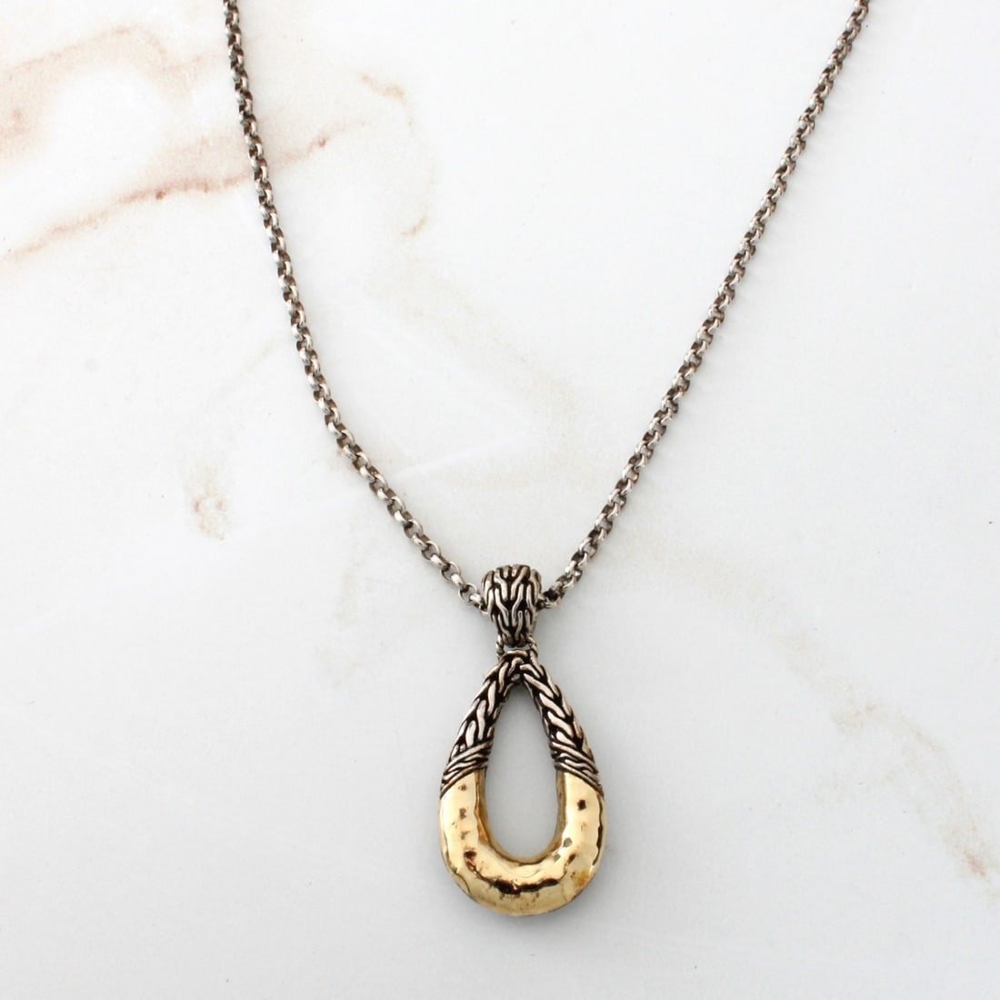 John Hardy Pendant Necklace: Vintage John Hardy 18 Karat Yellow Gold and Sterling Silver Pendant Necklace. Signed (logo). Pendant stamped 18K, 925. Chain clasp stamped 925. Pendant measures 1-1/8" L, 1/2" W; chain measures 18"