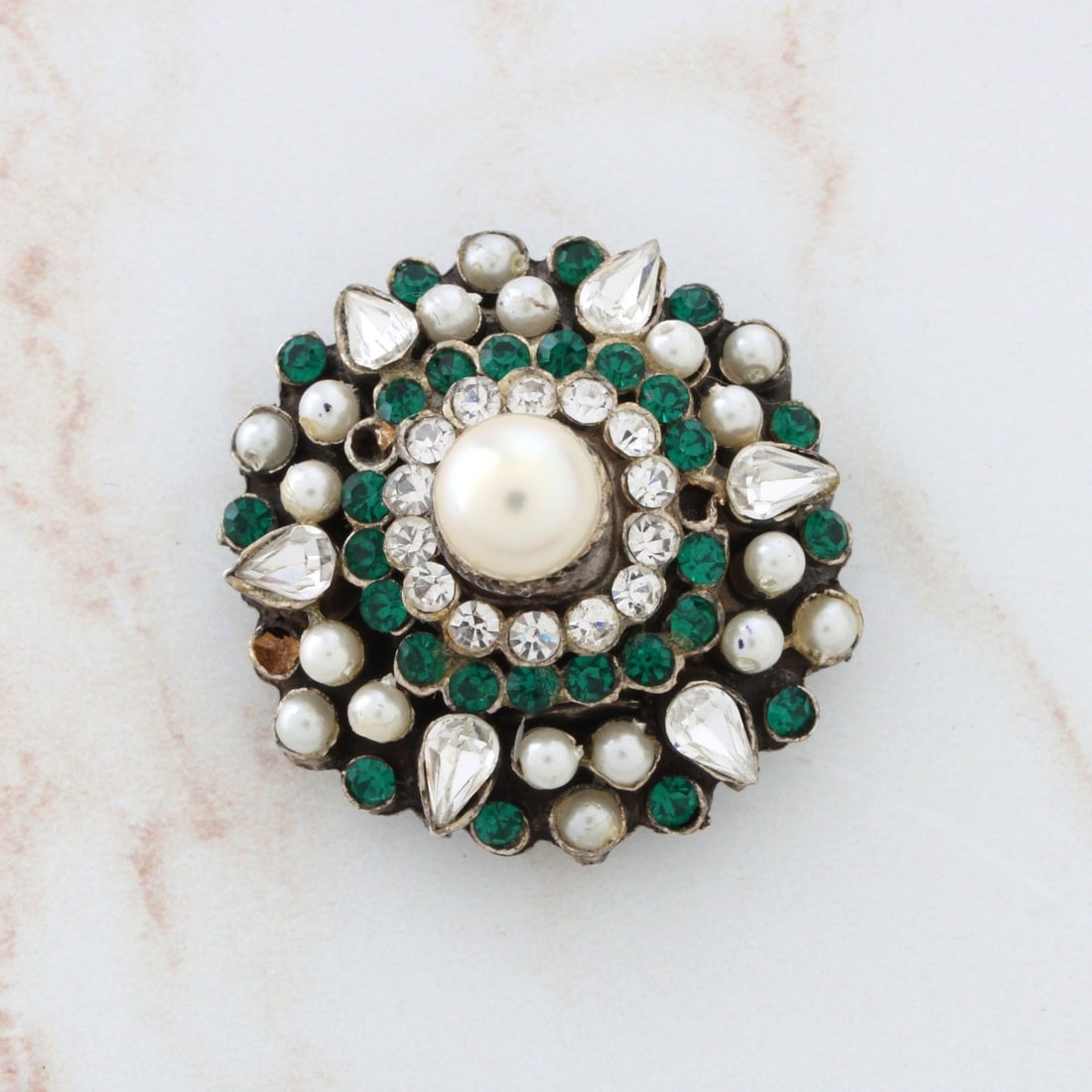 Gemstone, Pearl and Silver Brooch: Antique Pearl, Man Made Emeralds, Paste Diamonds and Silver Brooch. Largest pearl measures 8.0mm. Measures 1-1/4: diam. Approx. weight: 18.07 grams. Kodner Galleries offers phone and absentee bidding