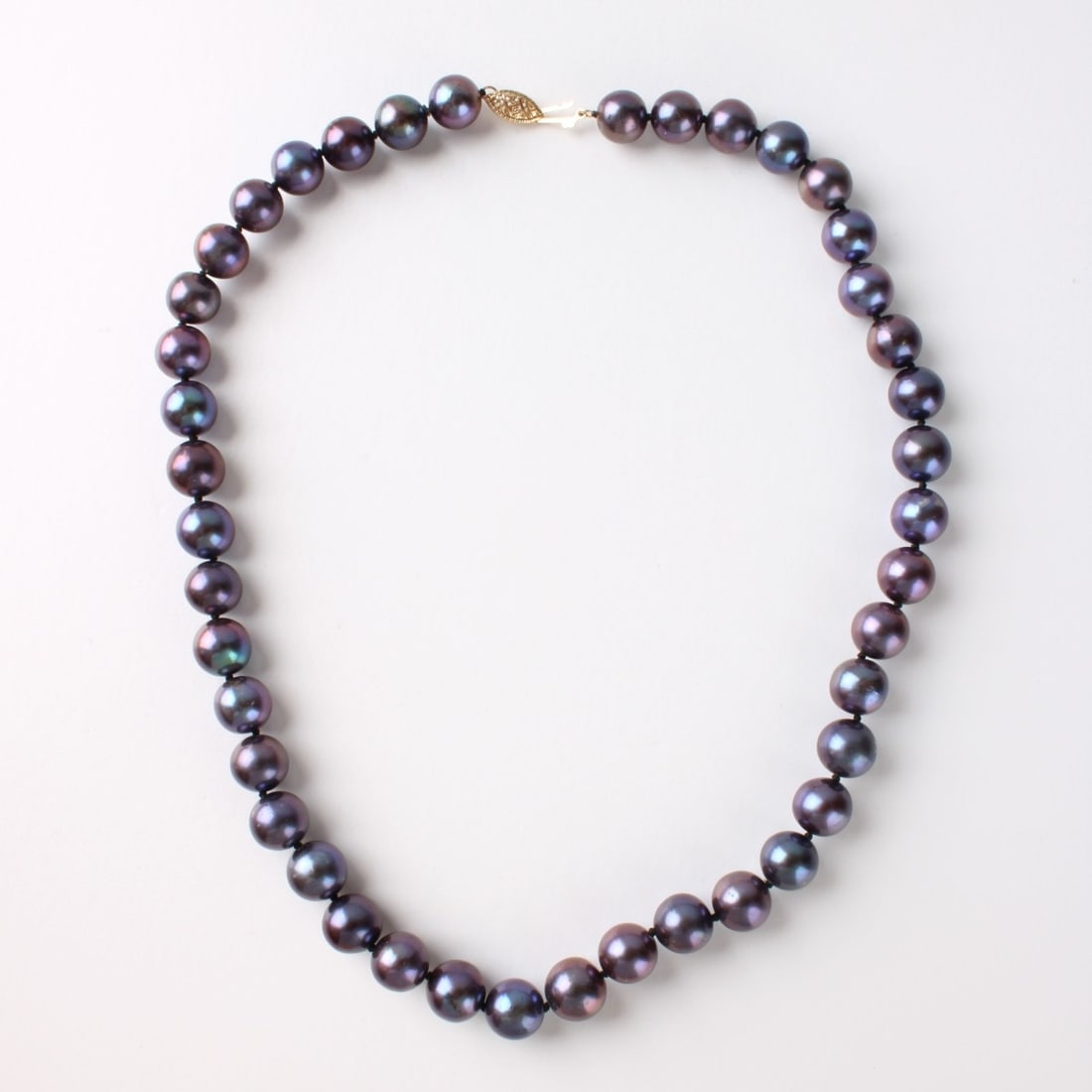 14K Yellow Gold and Pearl Necklace: Single Strand Black Pearl and 14K Yellow Gold Necklace. Clasp stamped 14K. Approximately 8.5mm, measures: 16-1/2" long. Total estimated gross weight: 1.85 troy ounces. Kodner Galleries offers phone