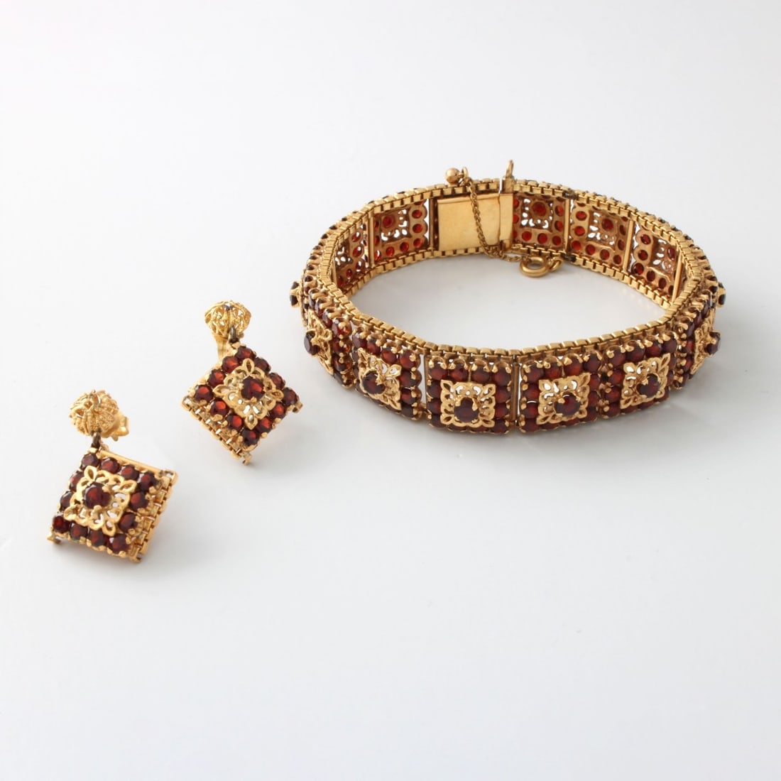 Garnet and 18K Bracelet and Earrings: Vintage Round Cut Garnet and 18 Karat Yellow Gold Flexible Link Bracelet and Pendant Earrings. Bracelet stamped 750. Earrings with 14 karat yellow gold backs. Bracelet measures 6-1/4" L, 1/2" W.