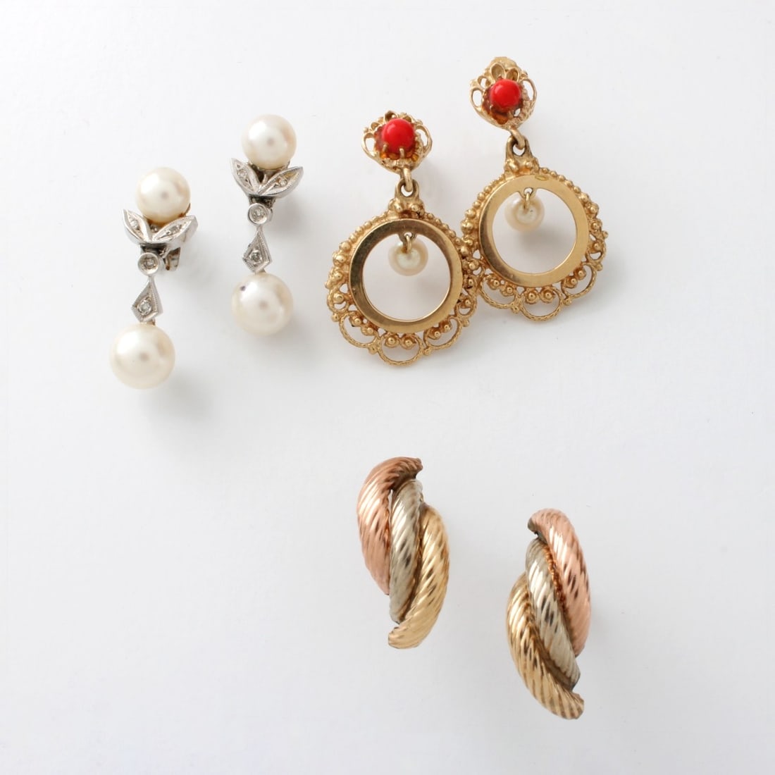 Three Pair 14K Earrings: Three (3) Pair of Vintage Delicate 14 Karat Gold Earrings. To include a pair of tri-color 14 karat gold huggie earrings, a pair of pearl, red coral and 14 karat yellow gold dangle earrings and a pair