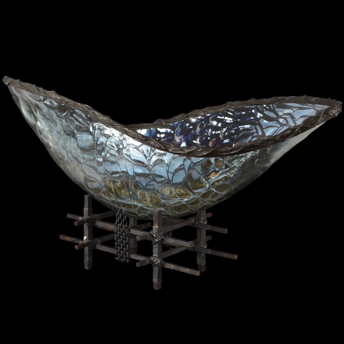 Scott Amrheim, American (20th Century): Scott Amrheim, American (20th Century) Oval glass Vessel Titled "Elliptical Oval Lumen," 2005. Signed and dated along the underside. The vessel with a woven metal rim. With a wooden and metal stand.