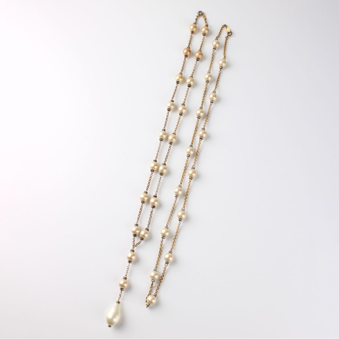 Baroque Pearl Necklaces: Two (2) Vintage Golden Baroque Pearl and Gold Tone Metal Necklaces Accented with Small Crystals. Each with Chanel Made in France tag. Pendant necklace measures 30" L, with 4" pendant drop. The other