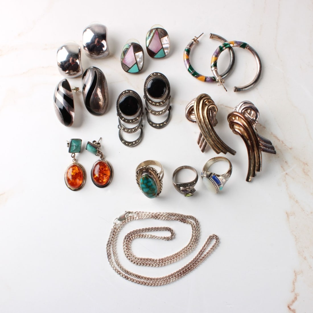 Sterling Silver Jewelry: Lot of Assorted Sterling Silver Jewelry. To include seven (7) pair of earrings, three (3) rings and one (1) chain / necklace. Variously accented with hardstones amber, shell and small gemstones. Most