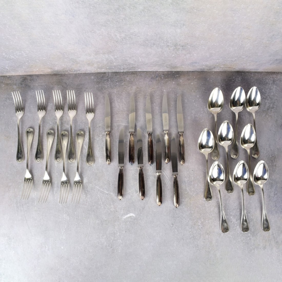 Christofle Silver Plated Tableware: Twenty-seven (27) Pieces Christofle Silver Plated Tableware. Includes 9 forks, measures: 8-1/8" L., 9 knives, measures: 8" L., 9 soup spoons, measures: 8-1/8" L. Forks and spoons monogrammed. Kodner