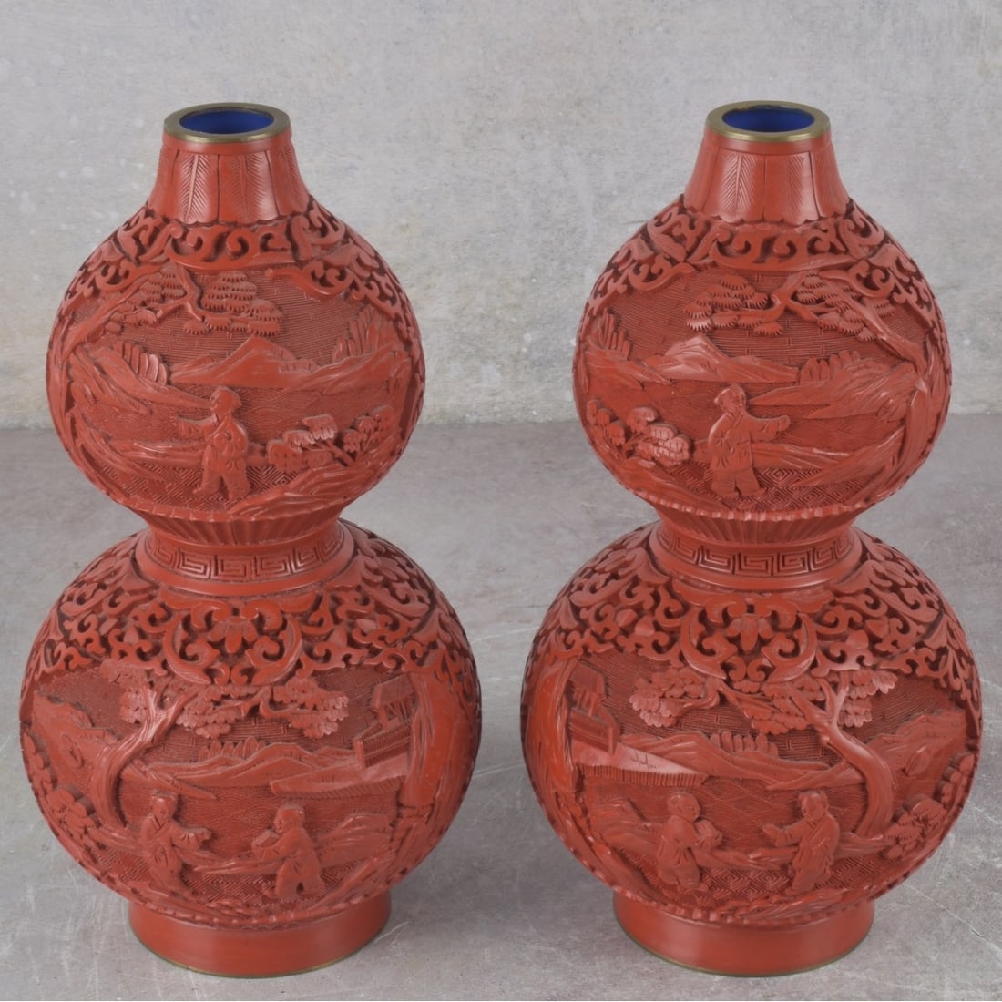 Vintage Chinese Cinnabar: Pair of Vintage Chinese Cinnabar Type Double Gourd Vases on Copper. Decorated with heavily carved figures, landscapes and village scenes. Measures: 9" high, 4-1/2" diameter. Kodner Galleries offers
